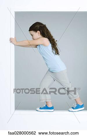 Little girl standing inside window frame, pushing edge, full length View Large Photo Image Stock Image - Little girl standing inside window frame, pushing edge, full length. Fotosearch