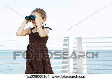 Little girl standing outdoors, looking through binoculars View Large Photo Image Picture - Little girl standing outdoors, looking through binoculars. Fotosearch