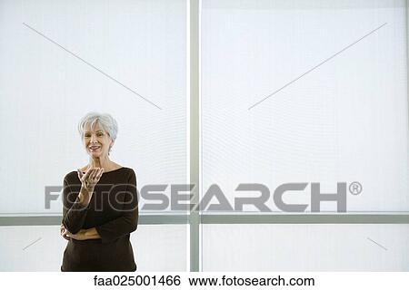 looking at camera, gesture, standing, woman, smiling, hand raised, senior women View Large Photo Image Stock Photograph - looking at camera, gesture, standing, woman, smiling, hand raised, senior women. Fotosearch