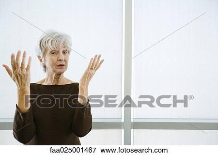 looking at camera, gesture, woman, uncertain, hand raised, senior women, body language View Large Photo Image Stock Photo - looking at camera, gesture, woman, uncertain, hand raised, senior women, body language. Fotosearch