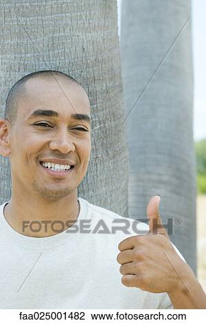 looking at camera, smiling, tree trunk, thumbs up, toothy smile, mid adult men View Large Photo Image Stock Image - looking at camera, smiling, tree trunk, thumbs up, toothy smile, mid adult men. Fotosearch