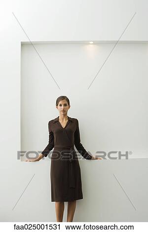 Stock Image - looking at camera, teenage girl, leaning against, standing, wall, indifference, anticipation. Fotosearch