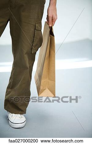 Man carrying paper shopping bag, low section, cropped View Large Photo Image Stock Image - Man carrying paper shopping bag, low section, cropped. Fotosearch