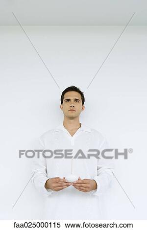 Man holding incense, looking away, waist up View Large Photo Image Stock Photography - Man holding incense, looking away, waist up. Fotosearch