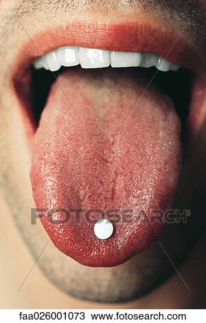 Man holding pill on tongue, extreme close-up View Large Photo Image Stock Image - Man holding pill on tongue, extreme close-up. Fotosearch