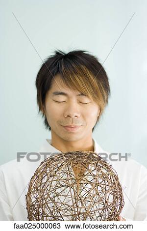 Man holding sphere, eyes closed View Large Photo Image Stock Image - Man holding sphere, eyes closed. Fotosearch