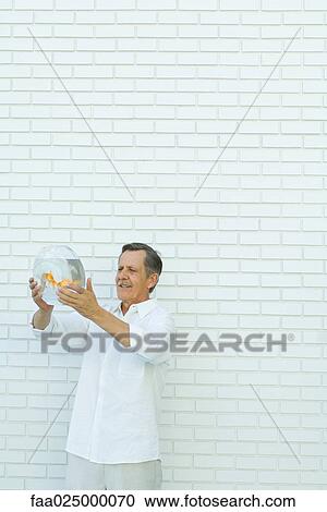 Man holding up goldfish bowl View Large Photo Image Stock Image - Man holding up goldfish bowl. Fotosearch