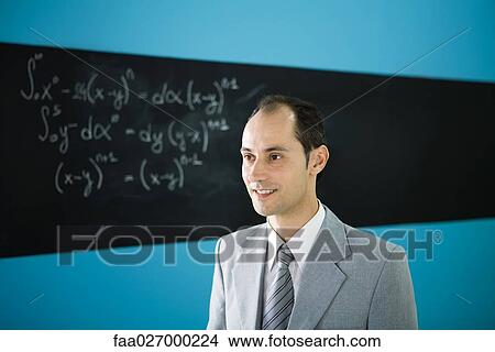 Man in suit looking away, smiling, mathematic equation on blackboard in background View Large Photo Image Picture - Man in suit looking away, smiling, mathematic equation on blackboard in background. Fotosearch