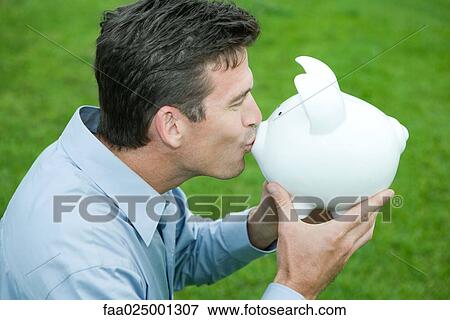 Man kissing piggy bank, side view View Large Photo Image Stock Photo - Man kissing piggy bank, side view. Fotosearch