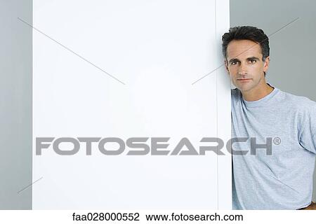Man leaning against edge of wall, looking at camera View Large Photo Image Stock Image - Man leaning against edge of wall, looking at camera. Fotosearch