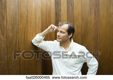 Man leaning elbow against wall, hand on head, looking away View Large Photo Image Stock Photography - Man leaning elbow against wall, hand on head, looking away. Fotosearch