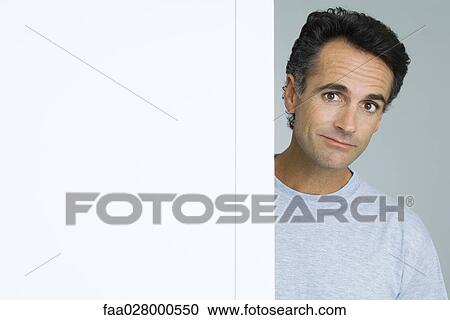 Man looking around corner of wall, portrait View Large Photo Image Stock Image - Man looking around corner of wall, portrait. Fotosearch
