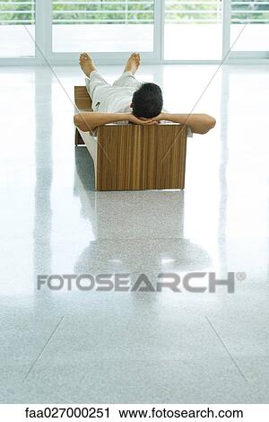 Man lying on bench, hands behind head, rear view View Large Photo Image Stock Image - Man lying on bench, hands behind head, rear view. Fotosearch