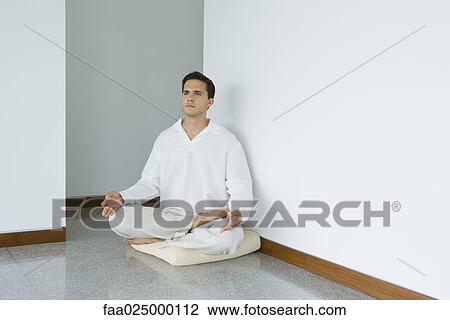 Man sitting in lotus position on cushion, looking away View Large Photo Image Stock Image - Man sitting in lotus position on cushion, looking away. Fotosearch