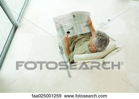 Man sitting, reading newspaper, high angle view View Large Photo Image Stock Photo - Man sitting, reading newspaper, high angle view. Fotosearch