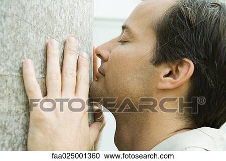 Man smelling tree trunk, eyes closed, side view, close-up View Large Photo Image Stock Image - Man smelling tree trunk, eyes closed, side view, close-up. Fotosearch
