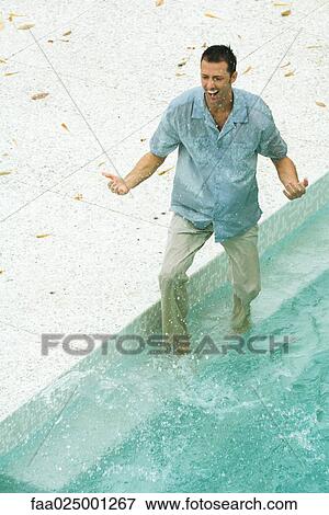 Man splashing in pool, fully clothed, high angle view View Large Photo Image Stock Photo - Man splashing in pool, fully clothed, high angle view. Fotosearch