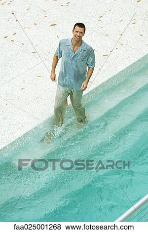 Man splashing in pool, fully clothed, smiling at camera, high angle view View Large Photo Image Stock Photo - Man splashing in pool, fully clothed, smiling at camera, high angle view. Fotosearch