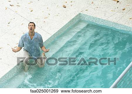 Man splashing in pool, fully clothed, shouting and gesticulating, high angle view View Large Photo Image Stock Photo - Man splashing in pool, fully clothed, shouting and gesticulating, high angle view. Fotosearch