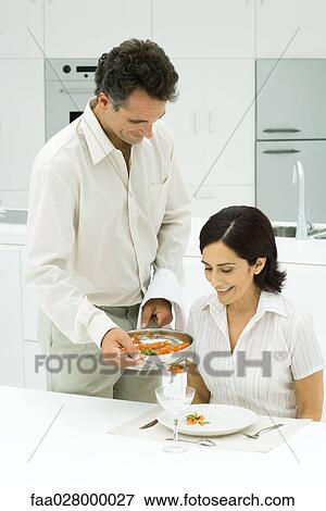 Man standing next to dinner table, serving meal to his wife View Large Photo Image Stock Photo - Man standing next to dinner table, serving meal to his wife. Fotosearch
