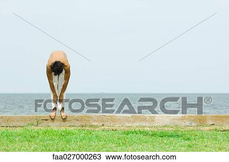 Man standing on low wall outdoors, bending over View Large Photo Image Stock Image - Man standing on low wall outdoors, bending over. Fotosearch