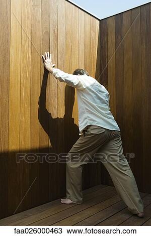 Man standing, pushing against wood paneling, side view View Large Photo Image Stock Image - Man standing, pushing against wood paneling, side view. Fotosearch