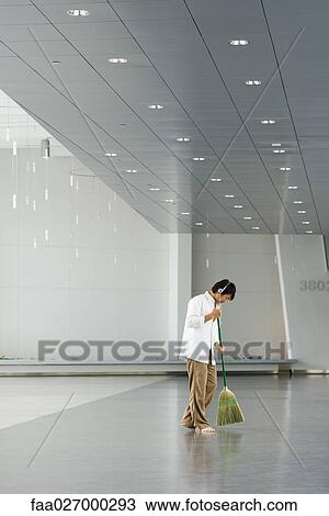 Man sweeping floor with broom, listening to headphones, side view View Large Photo Image Stock Image - Man sweeping floor with broom, listening to headphones, side view. Fotosearch