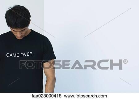 Stock Photo - Man wearing tee-shirt printed with the words "game over". Fotosearch