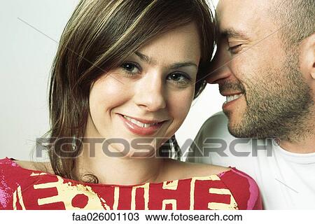 Man whispering in woman's ear, eyes closed, woman smiling at camera View Large Photo Image Stock Image - Man whispering in woman's ear, eyes closed, woman smiling at camera. Fotosearch