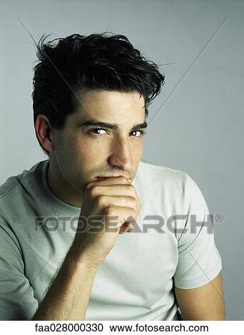 Man with hand under chin, looking at camera, portrait View Large Photo Image Stock Image - Man with hand under chin, looking at camera, portrait. Fotosearch