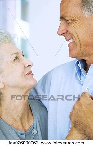 Mature couple smiling at each other, holding hands, close-up View Large Photo Image Stock Image - Mature couple smiling at each other, holding hands, close-up. Fotosearch