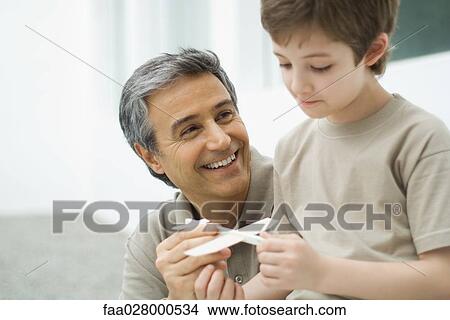 Picture - Mature man and boy holding toy plane. Fotosearch