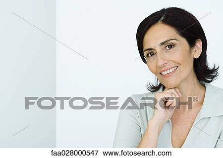 Mature woman, hand under chin, smiling at camera, portrait View Large Photo Image Stock Photo - Mature woman, hand under chin, smiling at camera, portrait . Fotosearch