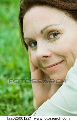Stock Image - Mature woman smiling at camera, close-up, portrait. Fotosearch