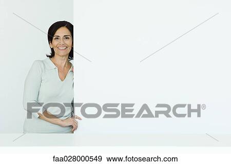 Mature woman, standing by edge of wall, smiling at camera, portrait View Large Photo Image Stock Photo - Mature woman, standing by edge of wall, smiling at camera, portrait . Fotosearch