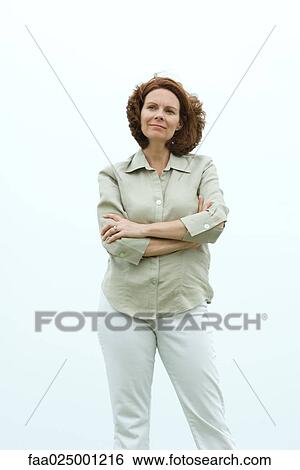 Mature woman standing with arms folded, smiling View Large Photo Image Stock Photograph - Mature woman standing with arms folded, smiling. Fotosearch