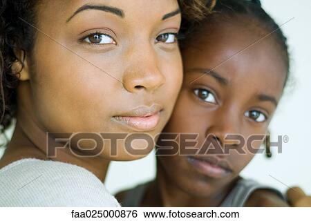 Mother and daughter embracing, looking at camera, cropped view View Large Photo Image Stock Photograph - Mother and daughter embracing, looking at camera, cropped view. Fotosearch