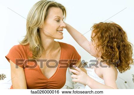 Mother and daughter looking at each other, smiling, girl's arm raised View Large Photo Image Stock Photograph - Mother and daughter looking at each other, smiling, girl's arm raised. Fotosearch