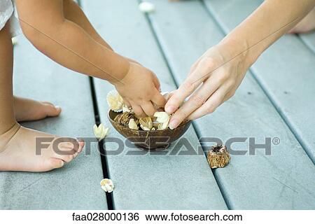 Mother and daughter picking up potpourri from bowl, cropped view View Large Photo Image Stock Photograph - Mother and daughter picking up potpourri from bowl, cropped view. Fotosearch