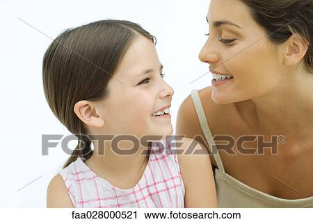 Mother and daughter smiling at each other, close-up View Large Photo Image Stock Image - Mother and daughter smiling at each other, close-up. Fotosearch