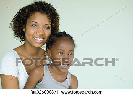 Mother and daughter smiling, looking away, portrait View Large Photo Image Stock Image - Mother and daughter smiling, looking away, portrait. Fotosearch