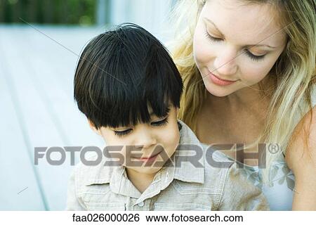 Mother and son looking down together, close-up View Large Photo Image Stock Photograph - Mother and son looking down together, close-up. Fotosearch