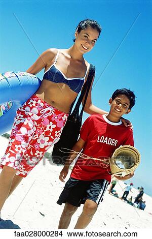 Mother and son walking at the beach, smiling at camera View Large Photo Image Picture - Mother and son walking at the beach, smiling at camera. Fotosearch