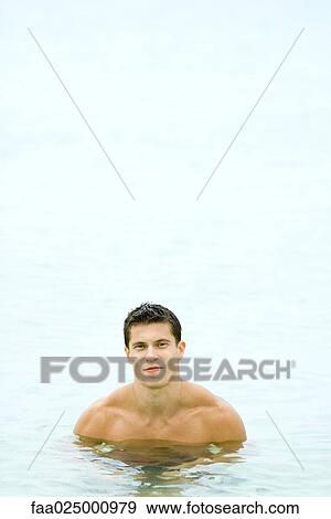 Muscular man chest deep in water, smiling at camera, front view View Large Photo Image Stock Photo - Muscular man chest deep in water, smiling at camera, front view. Fotosearch