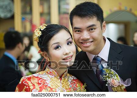 Newlyweds smiling at camera, bride dressed in traditional Chinese clothing View Large Photo Image Stock Image - Newlyweds smiling at camera, bride dressed in traditional Chinese clothing. Fotosearch