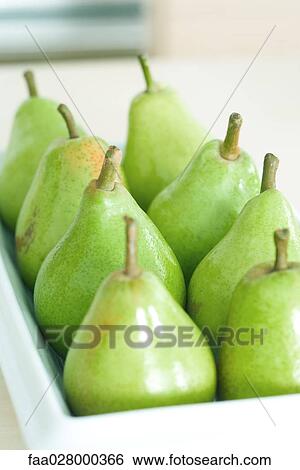 Stock Photograph - Pears lined up on tray, close-up. Fotosearch