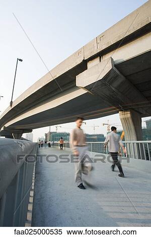 Pedestrians on footbridge under overpass View Large Photo Image Stock Photography - Pedestrians on footbridge under overpass. Fotosearch