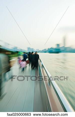Pedestrians walking by riverside, blurred motion View Large Photo Image Stock Image - Pedestrians walking by riverside, blurred motion. Fotosearch