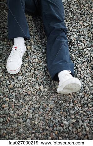 Person lying on gravel, low section, cropped view View Large Photo Image Stock Photo - Person lying on gravel, low section, cropped view. Fotosearch