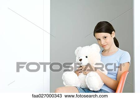 Preteen girl holding stuffed teddy bear, smiling at camera View Large Photo Image Stock Image - Preteen girl holding stuffed teddy bear, smiling at camera. Fotosearch